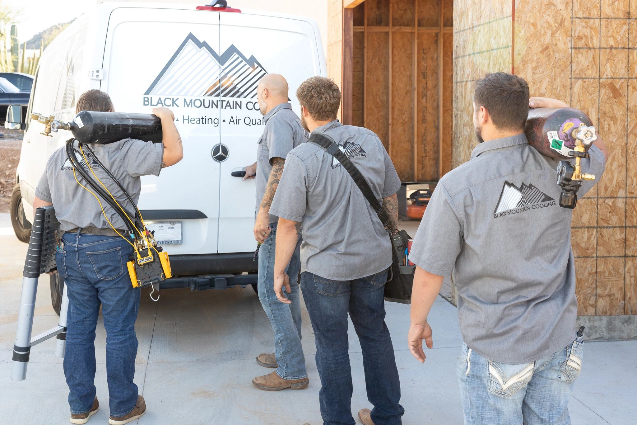 Black Mountain Cooling crew walking beside a branded service van
